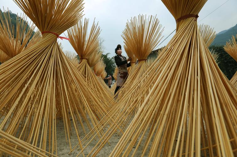 1月23日,在贵州省赤水市葫市镇一家竹制品加工企业,村民在晾晒竹丝.